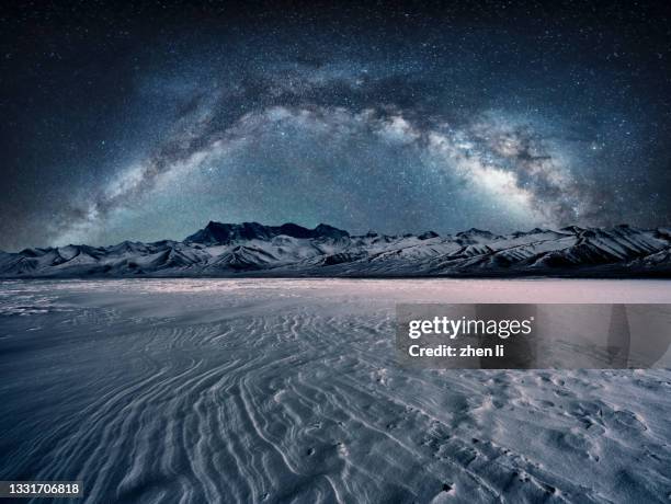 snowcapped mountain and flat snowfield under the galaxy arch bridge - glory road ストックフォトと画像