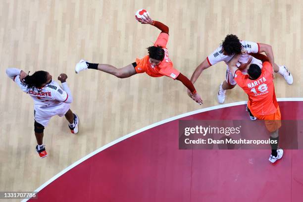 Hiroki Motoki of Team Japan shoots at goal under pressure from Gilberto Duarte and Luis Frade of Team Portugal during the Men's Preliminary Round...