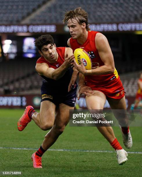 Noah Anderson of the Suns and Christian Petracca of the Demons contest the ball during the round 20 AFL match between Gold Coast Suns and Melbourne...