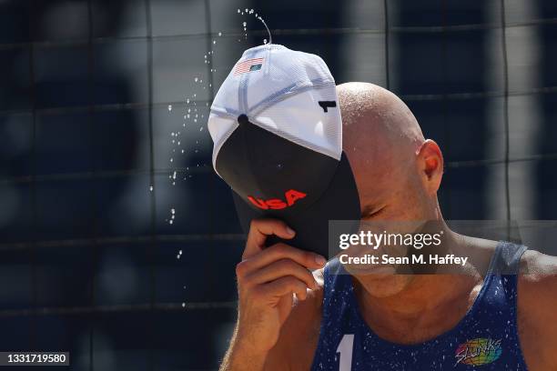 Sweat flies from the hat of Philip Dalhausser of Team United States between plays against Team Qatar during the Men's Round of 16 beach volleyball on...