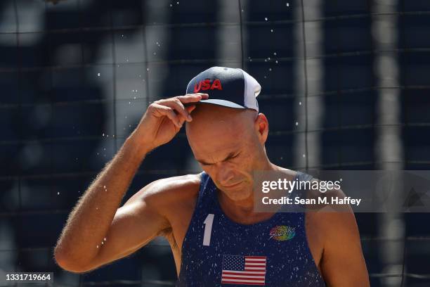 Sweat flies from the hat of Philip Dalhausser of Team United States between plays against Team Qatar during the Men's Round of 16 beach volleyball on...