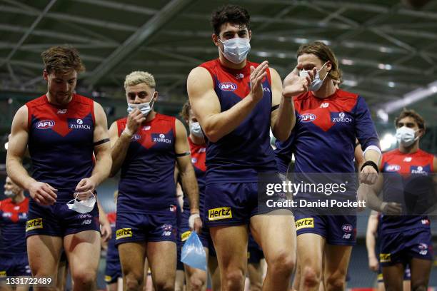 Christian Petracca of the Demons celebrates victory with teammates after the round 20 AFL match between Gold Coast Suns and Melbourne Demons at...