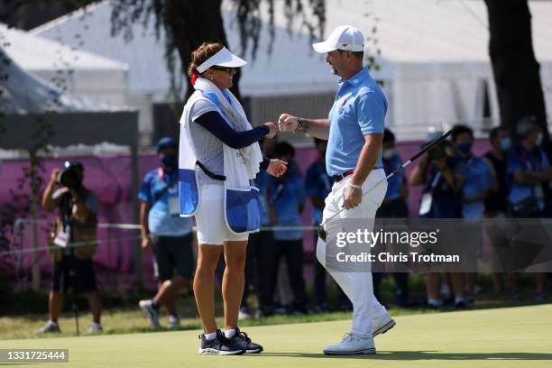 Rory Sabbatini of Team Slovakia celebrates his putt on the 18th green with caddie Martina Sabbatini during the final round of the Men's Individual...