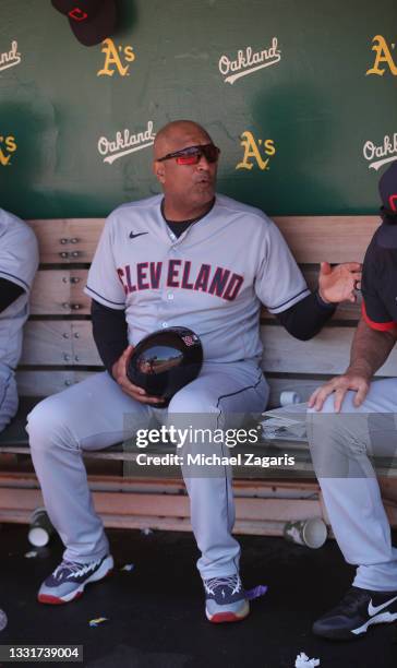 First base coach Sandy Alomar Jr. #15 of the Cleveland Indians in the dugout during the game against the Oakland Athletics at RingCentral Coliseum on...