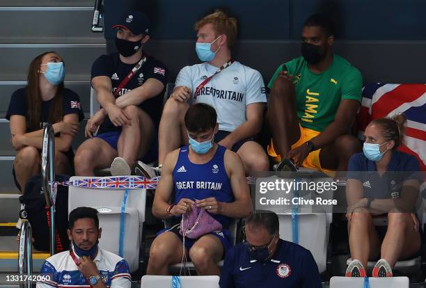 Tom Daley of Great Britain knits as he watches the Women's 3m Springboard Final on day nine of the Tokyo 2020 Olympic Games at Tokyo Aquatics Centre...