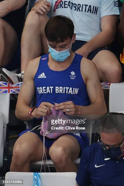 Tom Daley of Great Britain knits as he watches the Women's 3m Springboard Final on day nine of the Tokyo 2020 Olympic Games at Tokyo Aquatics Centre...