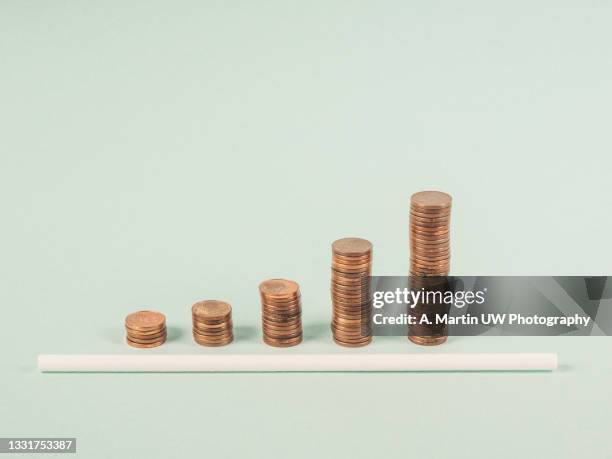 savings, increasing columns of coins isolated on a green background. concept of a business success - cost management stockfoto's en -beelden