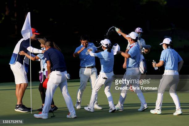 Pan of Team Chinese Taipei is congratulated after making his putt on the 18th green, the fourth playoff hole, to win the bronze medal during the...
