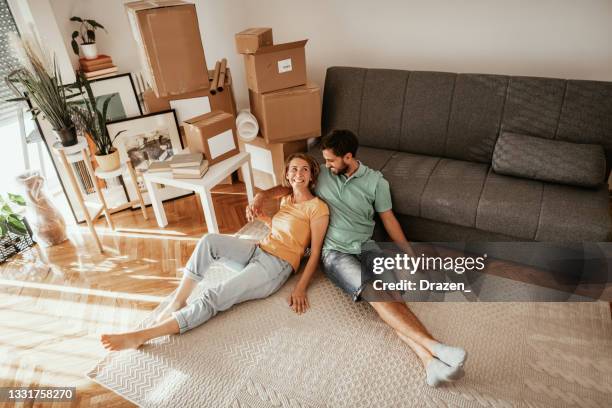 family moving in new apartment, lying on carpet and sharing love and happiness after moving in. - moving out stock pictures, royalty-free photos & images