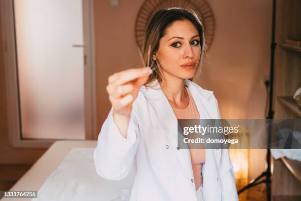 mulher acupunturista segurando agulhas de acupuntura - acupuncture - fotografias e filmes do acervo