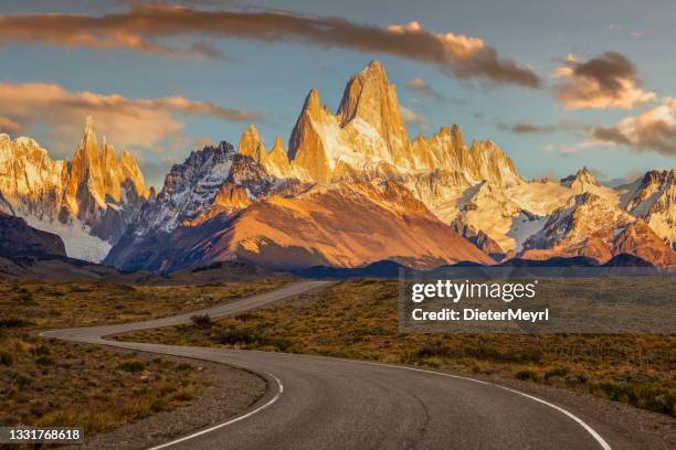 un camino ventoso conduce al monte fitz roy, las montañas circundantes y la ciudad de el chalten, argentina - patagonia fotografías e imágenes de stock