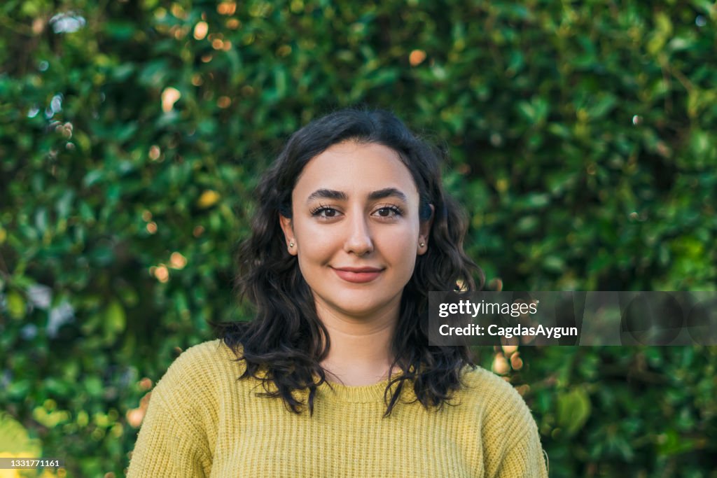 Smiling young woman on the background of lush leaves