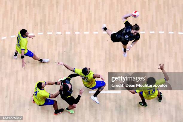 Juri Knorr of Team Germany shoots at goal as Thiago Ponciano and Thiagus Petrus of Team Brazil during the Men's Preliminary Round Group A handball...