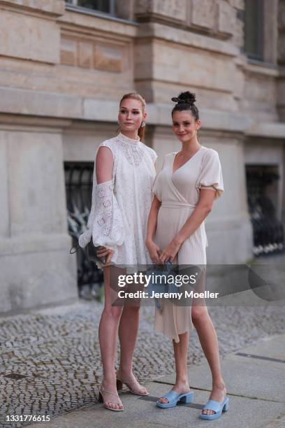 Betty Taube wearing a white lace dress and Jana Heinisch wearing a beige knit dress seen on July 29, 2021 in Berlin, Germany.