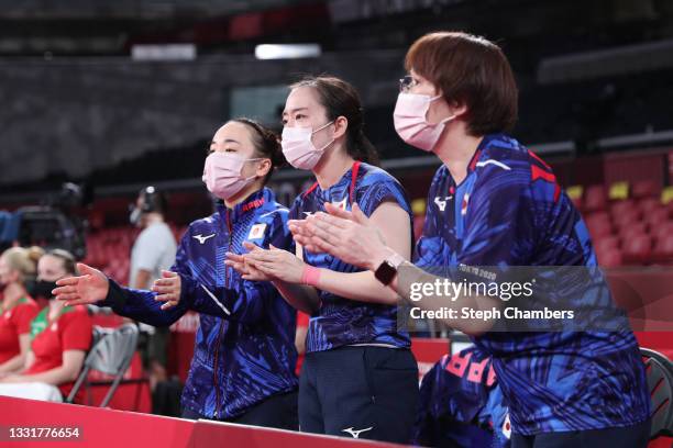 Team Japan players Ito Mima , Ishikawa Kasumi and coach Baba Mika cheer during their Women's Team Round of 16 table tennis match on day nine of the...