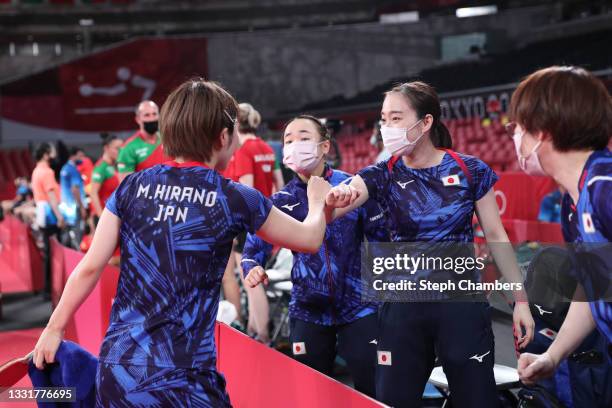 Ito Mima of Team Japan shakes hands with her teammates Miu Hirano and Kasumi Ishikawa during her Women's Team Round of 16 table tennis match on day...