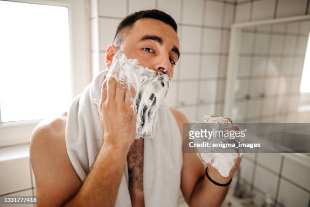 happy man applying shaving foam at bathroom mirror - man shaving foam stock pictures, royalty-free photos & images