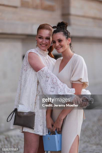 Betty Taube wearing a white lace dress and Jana Heinisch wearing a beige knit dress seen on July 29, 2021 in Berlin, Germany.