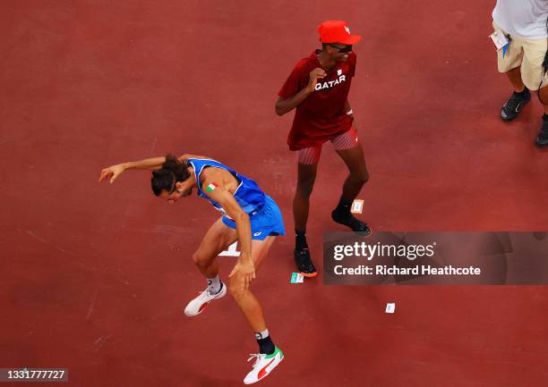 Gianmarco Tamberi of Team Italy and Mutaz Essa Barshim of Team Qatar react after winning the gold medal in the men's High Jump on day nine of the...