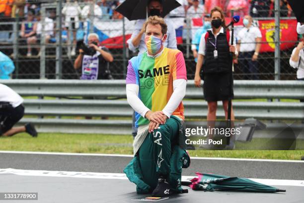 Sebastian Vettel of Germany and Aston Martin F1 Team takes a knee on the grid as part of the We Race As One gesture before the F1 Grand Prix of...