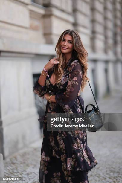 Farina Opoku wearing a long floral dress and black Prada bag on July 29, 2021 in Berlin, Germany.