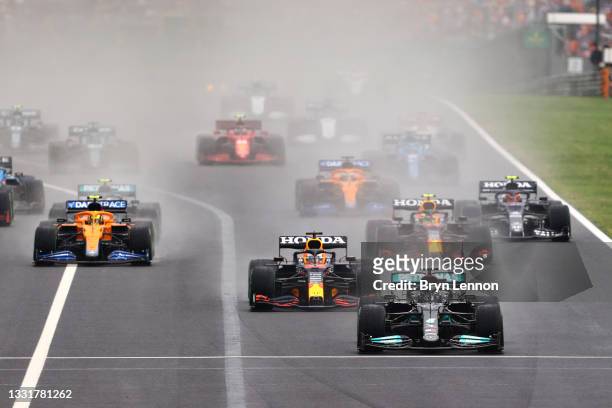 Lewis Hamilton of Great Britain driving the Mercedes AMG Petronas F1 Team Mercedes W12 leads the field into turn one at the start during the F1 Grand...