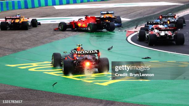 Sergio Perez of Mexico driving the Red Bull Racing RB16B Honda runs wide at the start as cars tangle ahead of him during the F1 Grand Prix of Hungary...