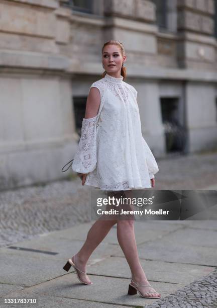Jana Heinisch wearing a white lace dress and beige sandals on July 29, 2021 in Berlin, Germany.