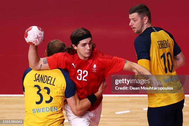 Jacob Holm of Team Denmark is challenged by Lukas Sandell of Team Sweden as Niclas Ekberg of Team Sweden looks on during of the Men's Preliminary...