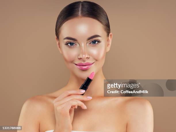 beautiful girl applying make-up - gloss stockfoto's en -beelden