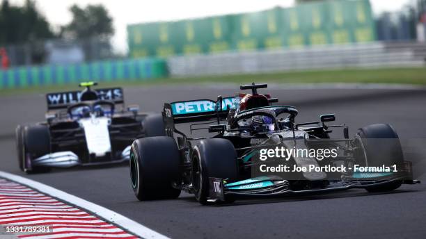 Lewis Hamilton of Great Britain driving the Mercedes AMG Petronas F1 Team Mercedes W12 leads Nicholas Latifi of Canada driving the Williams Racing...