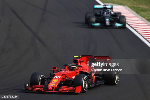 Carlos Sainz of Spain driving the Scuderia Ferrari SF21 leads Lewis Hamilton of Great Britain driving the Mercedes AMG Petronas F1 Team Mercedes W12...