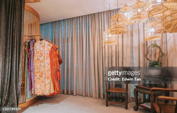 interior retro style chinese tradition cheongsam boutique gallery bird cage decoration, antique wooden chair at corner - the cheongsam stock pictures, royalty-free photos & images