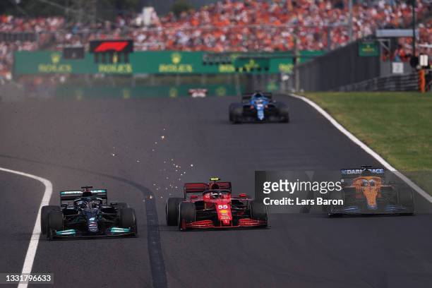 Lewis Hamilton of Great Britain driving the Mercedes AMG Petronas F1 Team Mercedes W12 overtakes Carlos Sainz of Spain driving the Scuderia Ferrari...