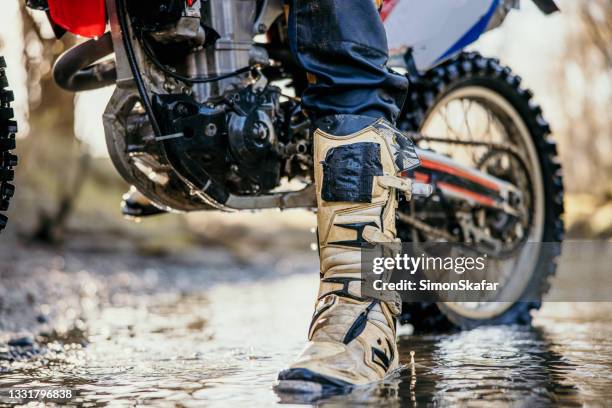 pilote de motocross sur un ruisseau dans la forêt - motocross stock photos et images de collection