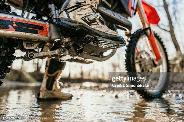 motocross rider riding through stream in forest - riding boot stock pictures, royalty-free photos & images