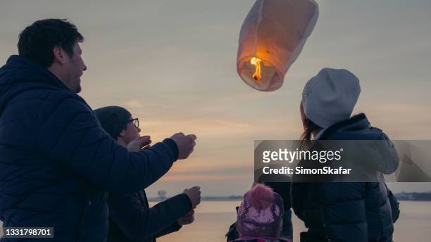 family releasing burning sky lantern - makar sankranti 個照片及圖片檔
