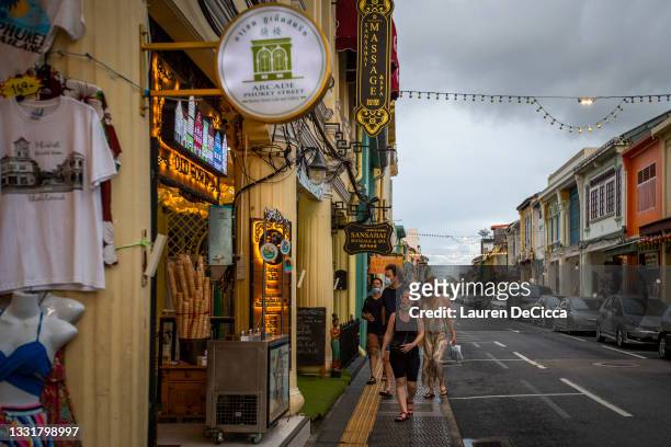 Sandbox travelers walk down the once busy streets of Phuket Old Town on August 01, 2021 in Phuket, Thailand. Phuket Town remains a cultural center of...