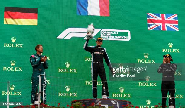 Race winner Esteban Ocon of France and Alpine F1 Team, second placed Sebastian Vettel of Germany and Aston Martin F1 Team and third placed Lewis...