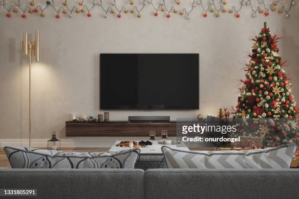 wohnzimmer interieur mit weihnachtsbaum, ornamenten, geschenkboxen, rotem sofa und lcd-fernseher - living room television stock-fotos und bilder