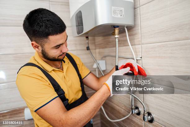 technician repairing an hot-water heater - caldeira imagens e fotografias de stock