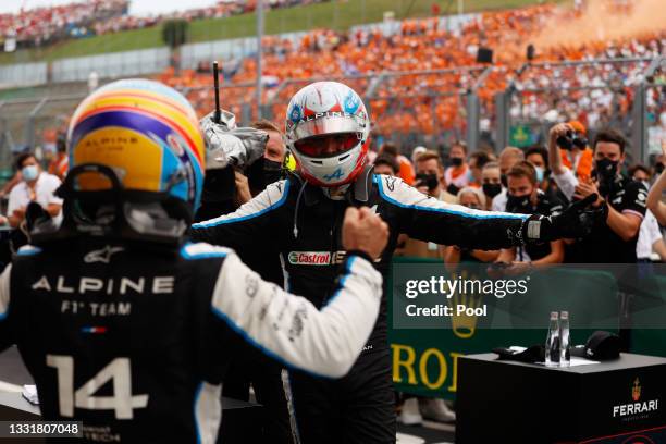 Race winner Esteban Ocon of France and Alpine F1 Team and fifth placed Fernando Alonso of Spain and Alpine F1 Team celebrate in parc ferme during the...