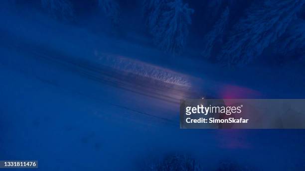 high angle view of car traveling on road in snow covered forest - snow covered road stockfoto's en -beelden