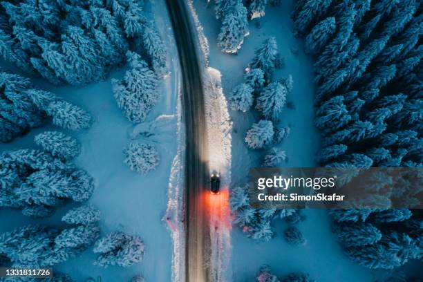 hochwinkelansicht des autos auf der straße im schneebedeckten wald - snowy road stock-fotos und bilder