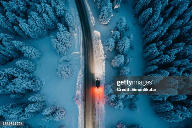 vista de alto ángulo del coche en la carretera en el bosque cubierto de nieve - nieve profunda fotografías e imágenes de stock