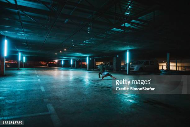 mann, der breakdance-bewegungen auf dem parkplatz durchführt - fluorescent stock-fotos und bilder