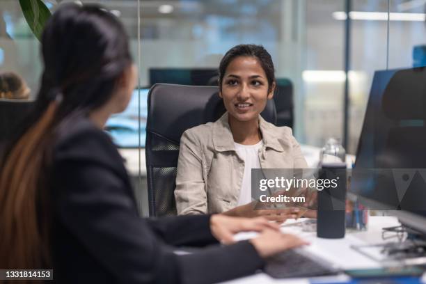 des collègues de travail féminins parlent dans un bureau - financial analyst photos et images de collection