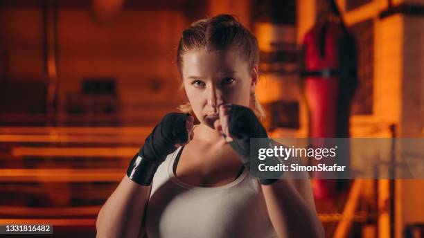 portrait of female boxer in fighting pose - fighting stance stock pictures, royalty-free photos & images