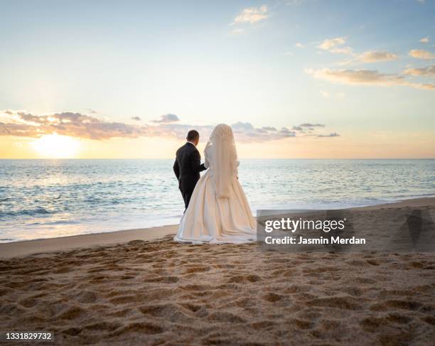 islamic wedding couple on beach near sunset - sunset beach bouquet wedding couple stock pictures, royalty-free photos & images