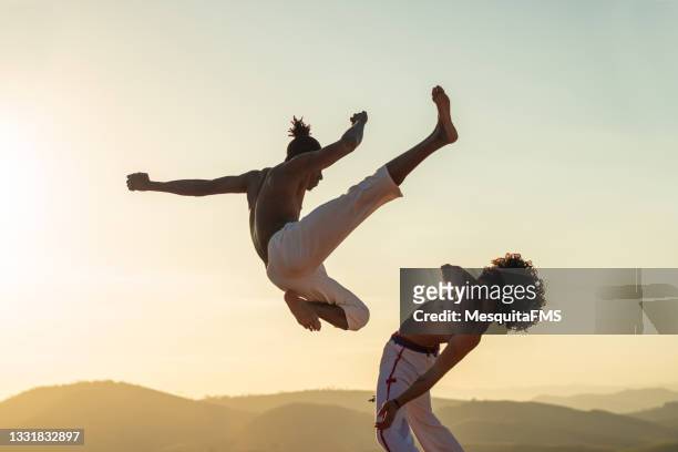capoeira fighter jumping kicking - brazilian dancer stockfoto's en -beelden
